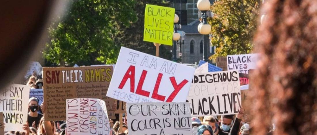 Protest signs are held up at a Black Lives Matter public protest.