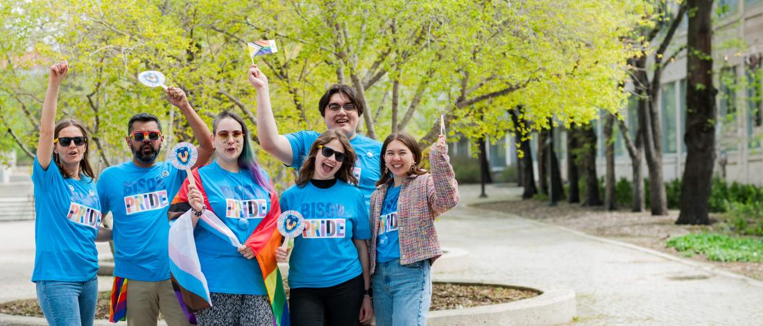 um community members holding a pride flag and wearing UM Pride t-shirts