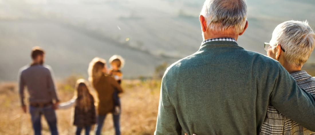 An older couple watching their family from a distance