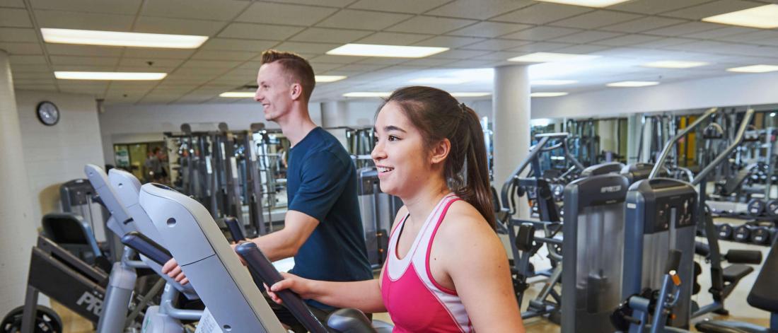 A man and woman exercising in the Joe Doupe recreation facility