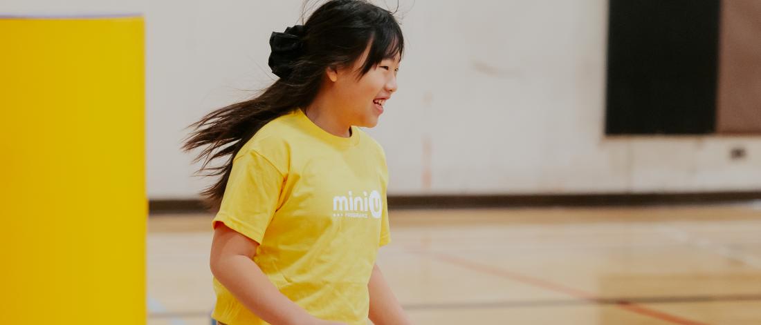 child in mini u shirt running and smiling