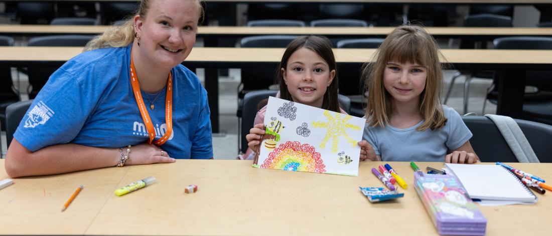 children and leader posing with drawing