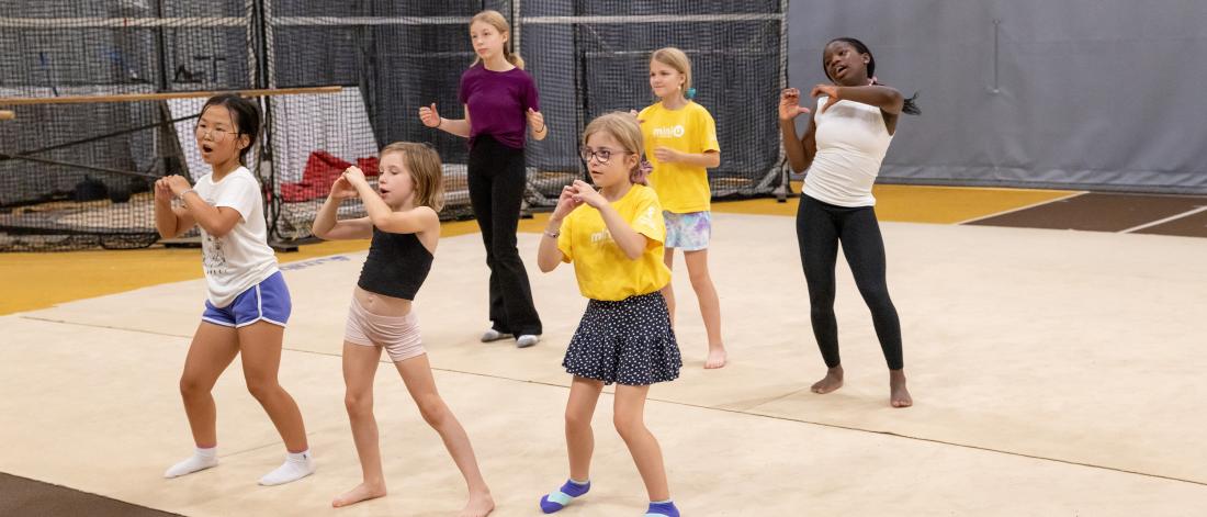 A group of children preform choreography.