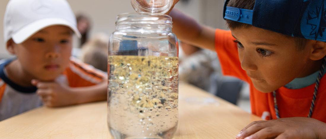 children pouring oil substance into water