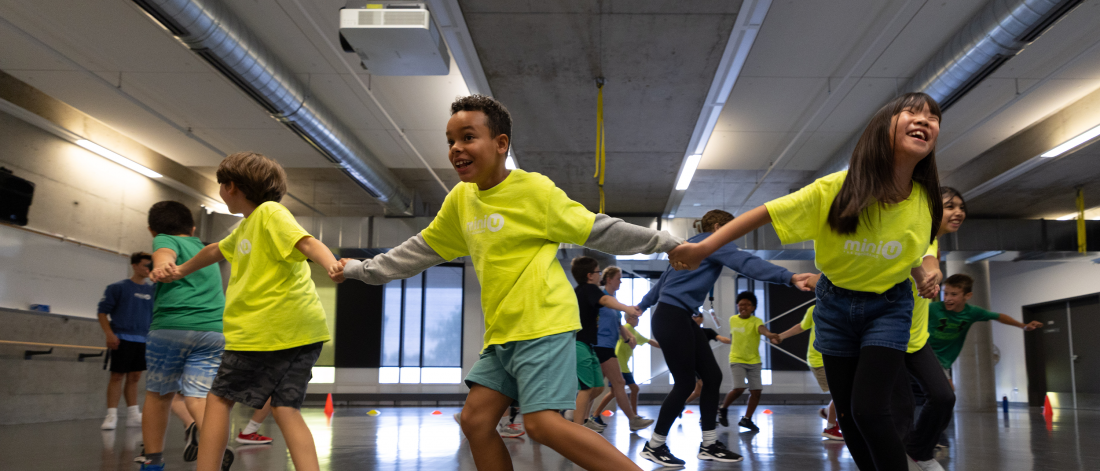 A group of Mini U campers holding hands and spinning in a circle