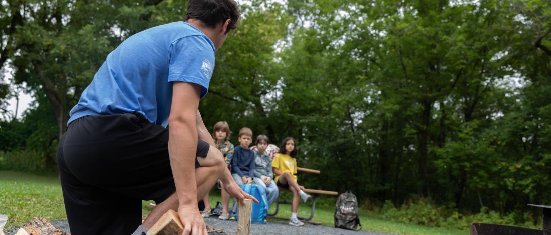leader splitting wood for a fire