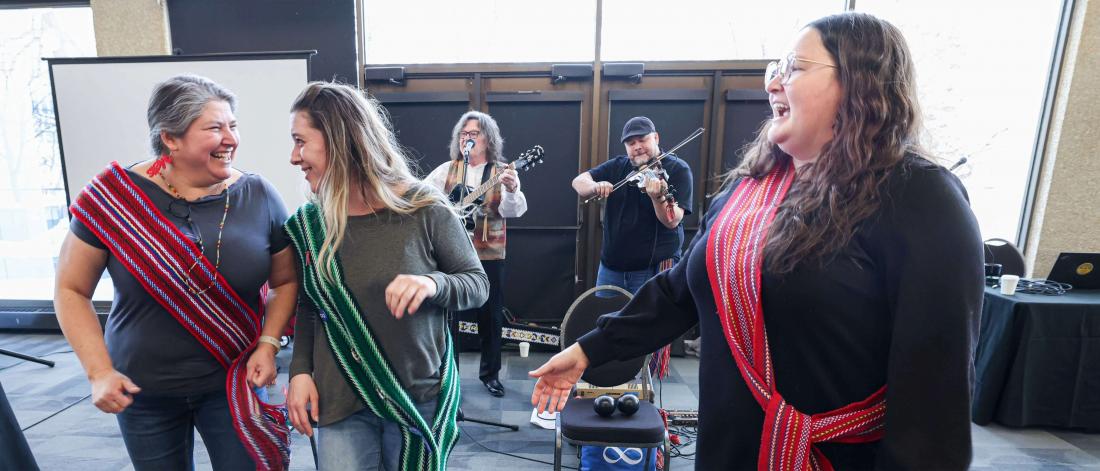 Members of the Metis community smile as musicians play.