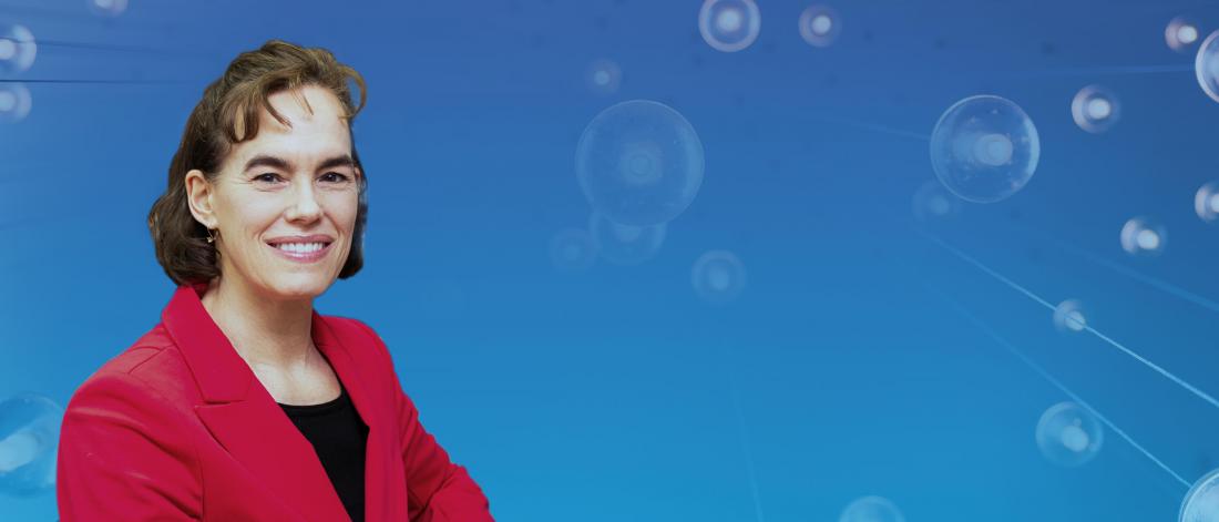 Portrait of Andrea Charron smiling, set against a blue background with abstract circular light elements.