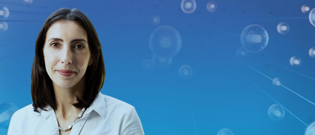 Head-and-shoulders portrait of a person in a white shirt against a blue background with abstract cell-like graphics.