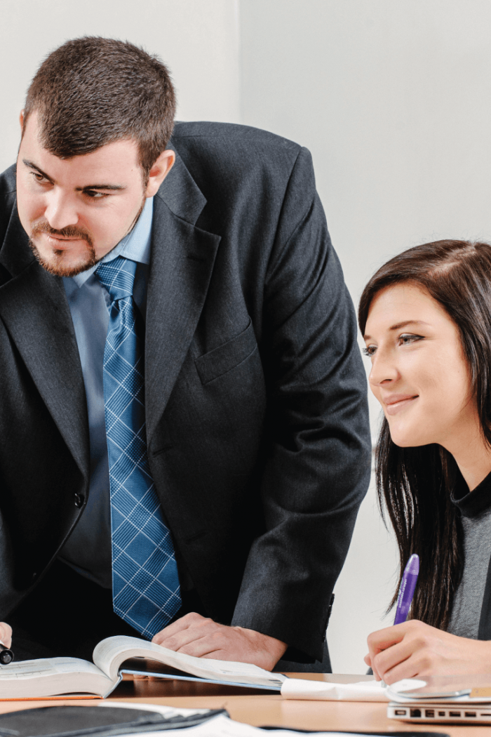 Two Asper School of Business students work together at a table.