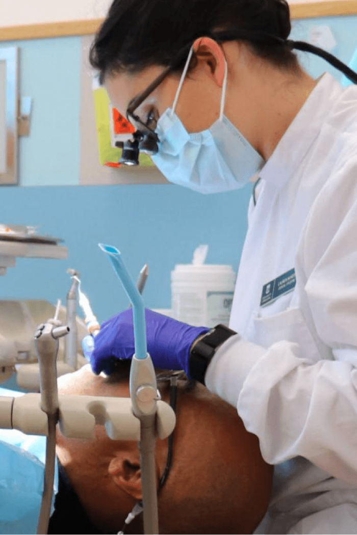 A student practices cleaning a patients teeth. 