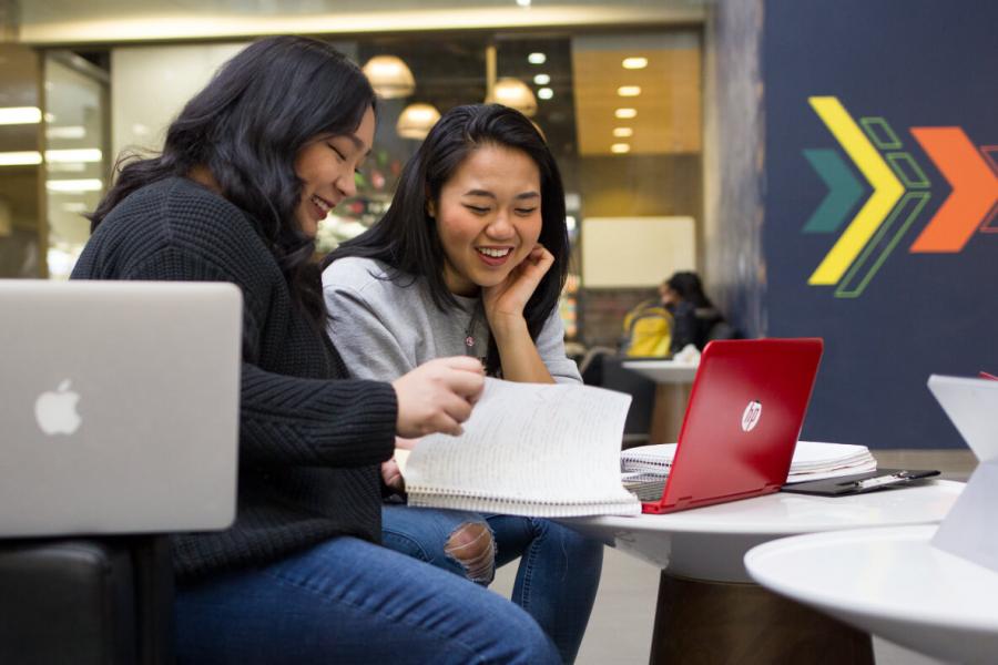 two students smiling and studying