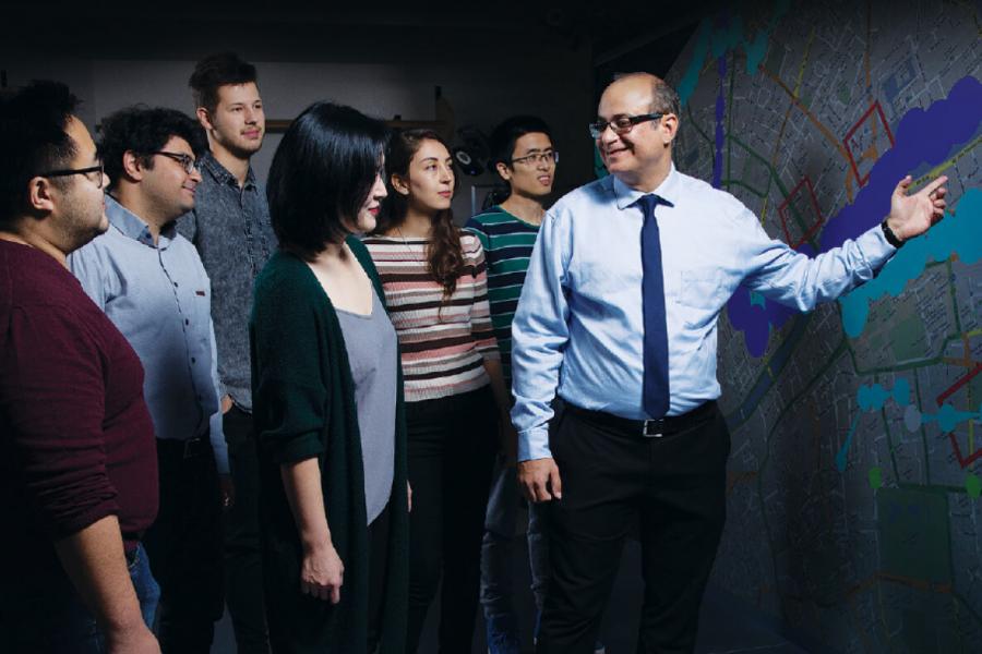 A University of Manitoba instructor speaking to a group of students and gesturing to a map.