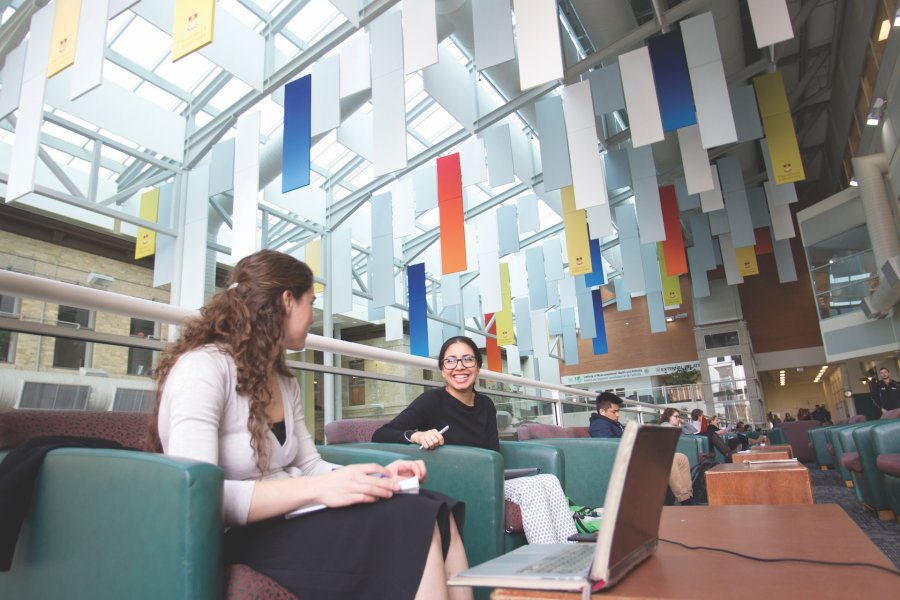 Two people talking in the Brodie Centre Atrium