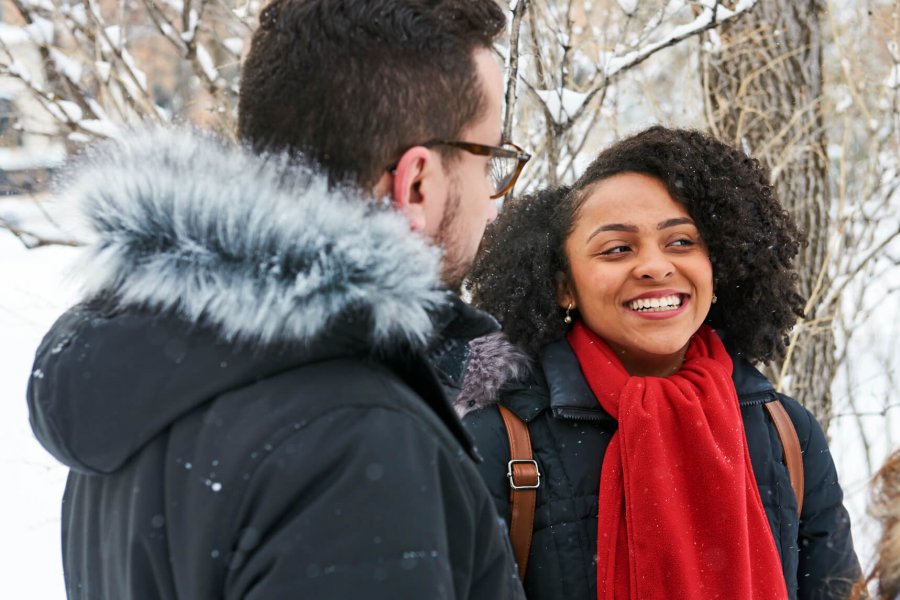 Two University of Manitoba International students talking outside while it is snowing.