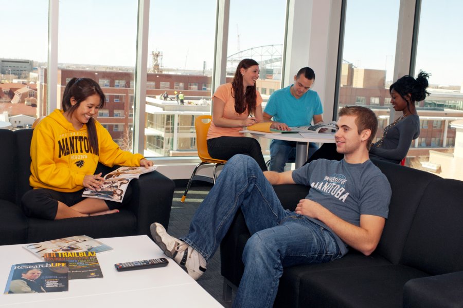 Several students reading, watching television and studying in a residence lounge room.