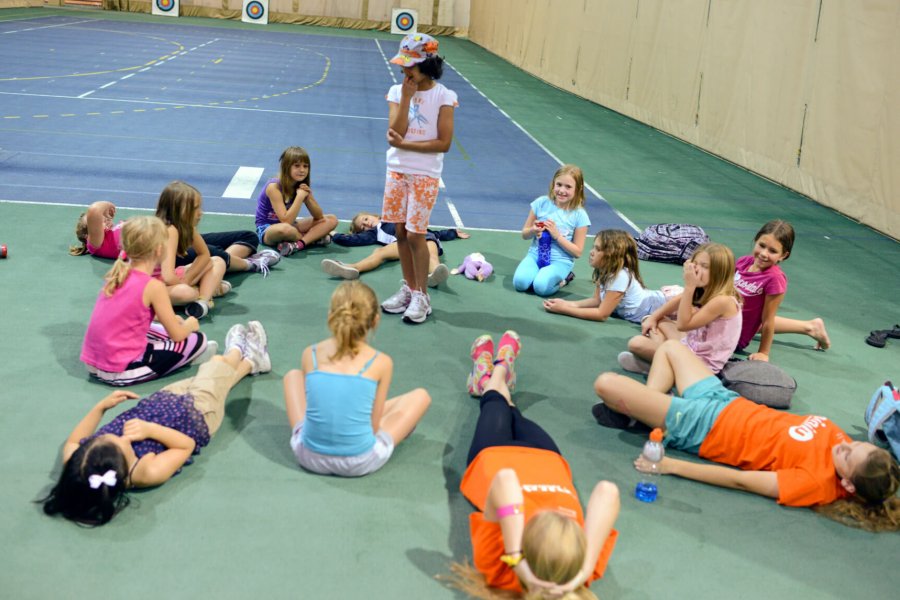 A group of junior cheerleaders stretch before practice.