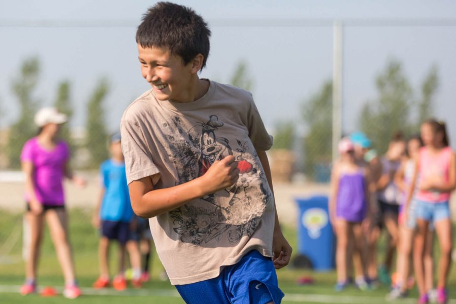 A junior program participant runs through soccer practice drills.