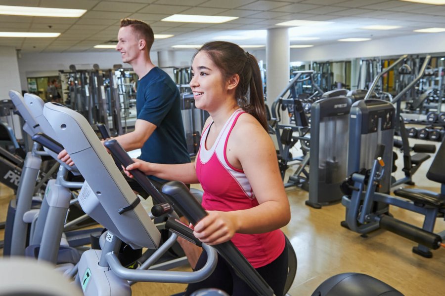 A man and woman getting a workout using the cardiovascular equipment at the Joe Doupe Recreation Centre.