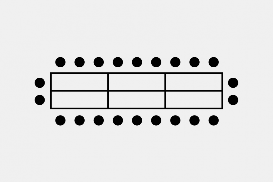 A boardroom style seating arrangement with 6 rectangular tables creating one long table with a row of chairs along each long edge.