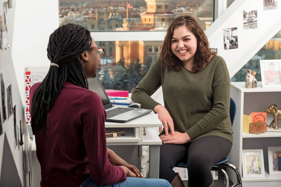 Two students hang out in a Pembina Hall dorm room. 