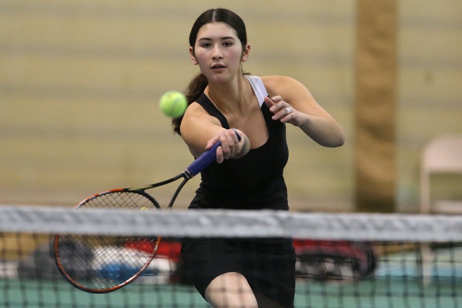 student playing tennis indoors