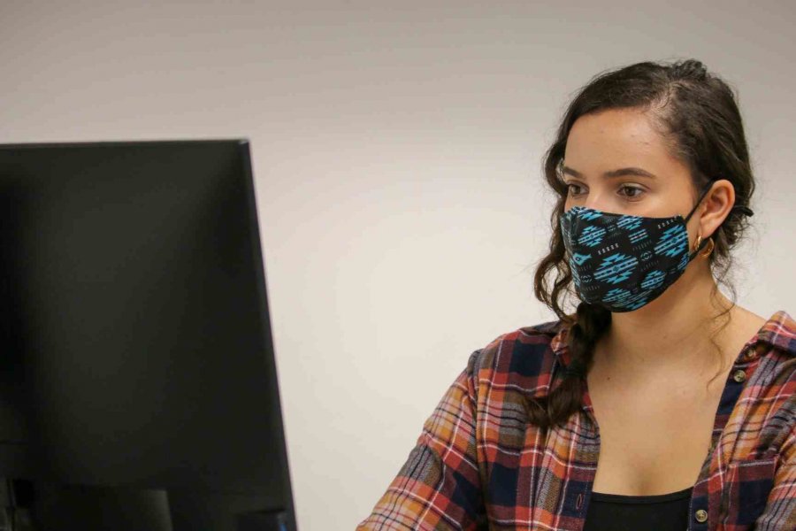 Student wearing a mask working on a computer