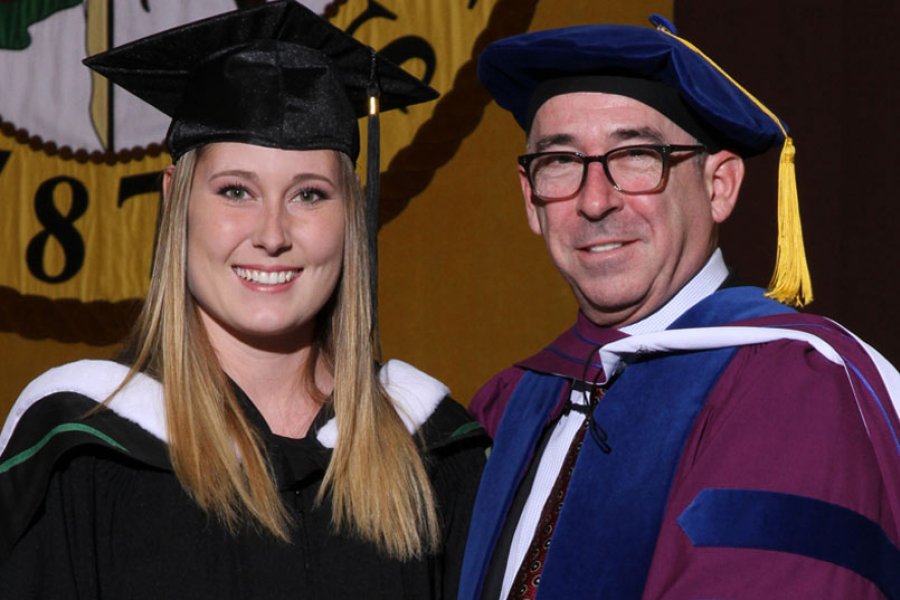 A graduand poses for her graduate photo with a university authority figure.