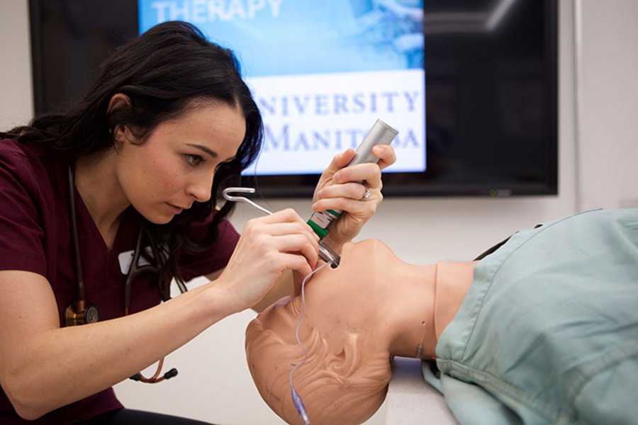 A respiratory therapy student practices her skills on a medical manikin.