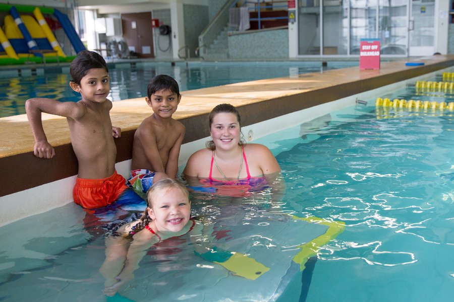 children in swimming pool with instructor