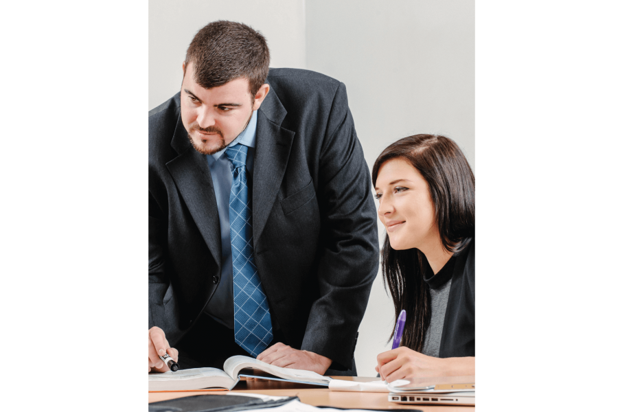 Two Asper School of Business students work together at a table.