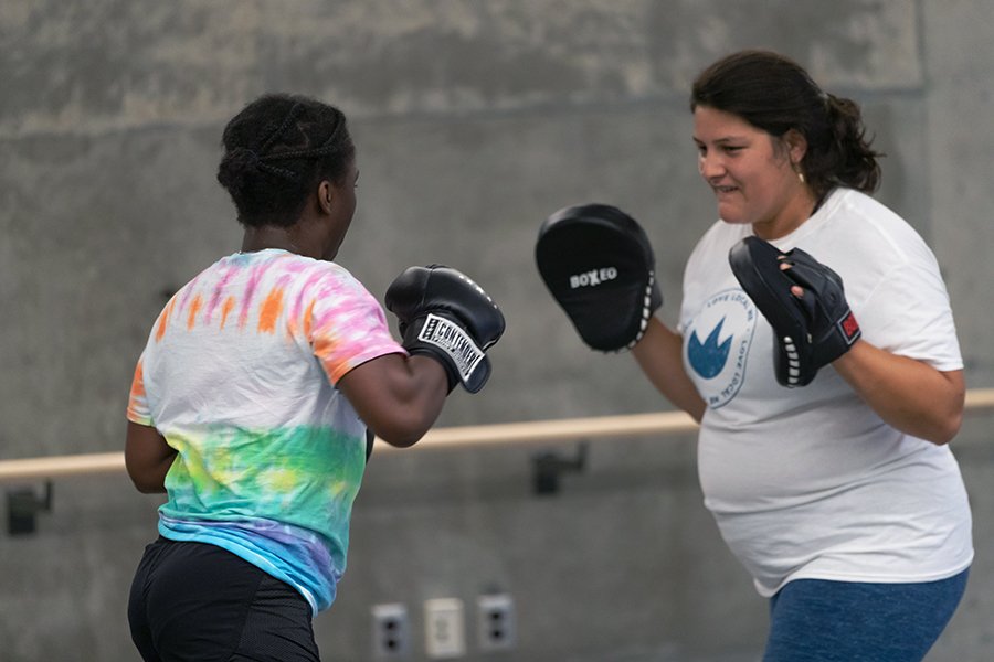 two people boxing with pads and gloves