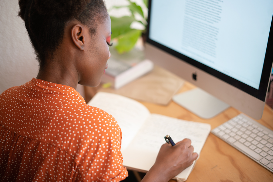 Woman on desk with notepad and computer