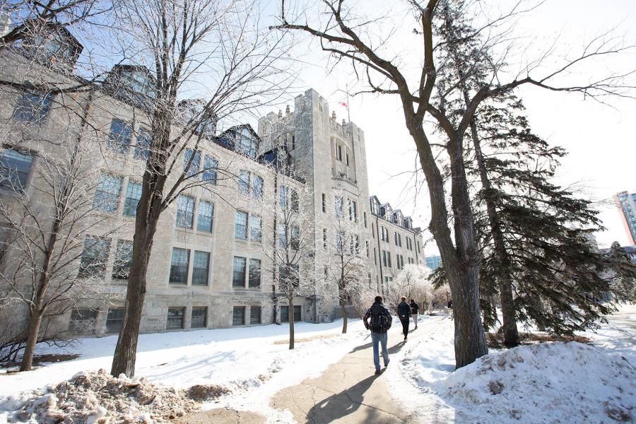 Students walk the path in front of Tier Building on Fort Garry campus in winter.