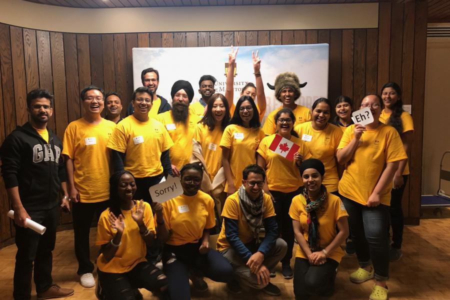 Group of students posing for photo wearing yellow volunteer t-shirts