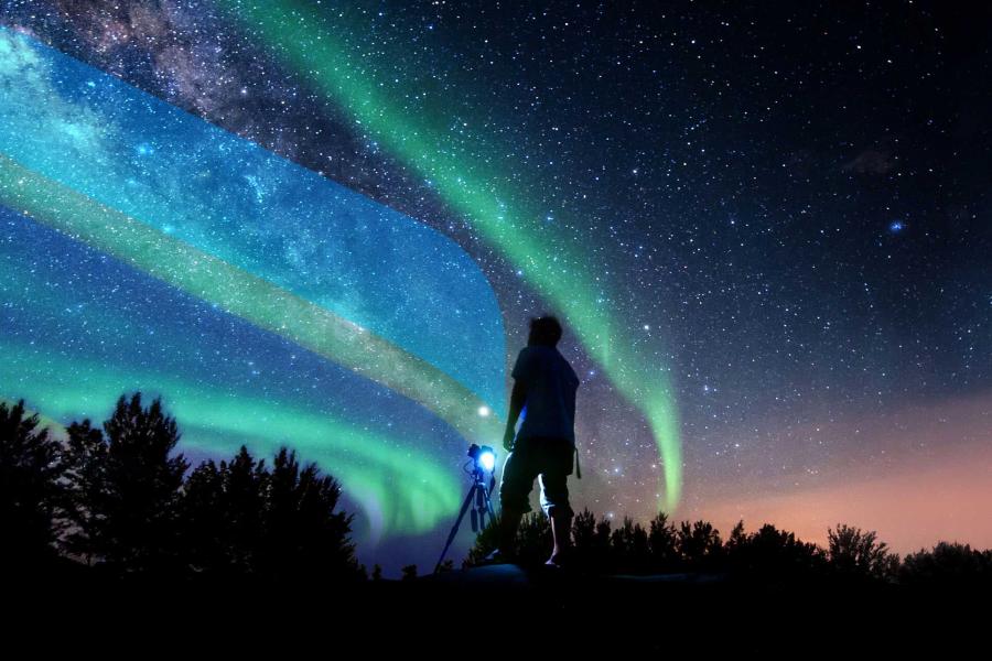 A silhouette of a photographer in front of a night sky that has stars and the northern lights overlaid with U M branding. 