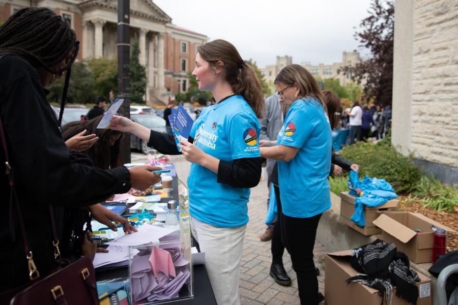 Students handing out information to new students for Orientation.