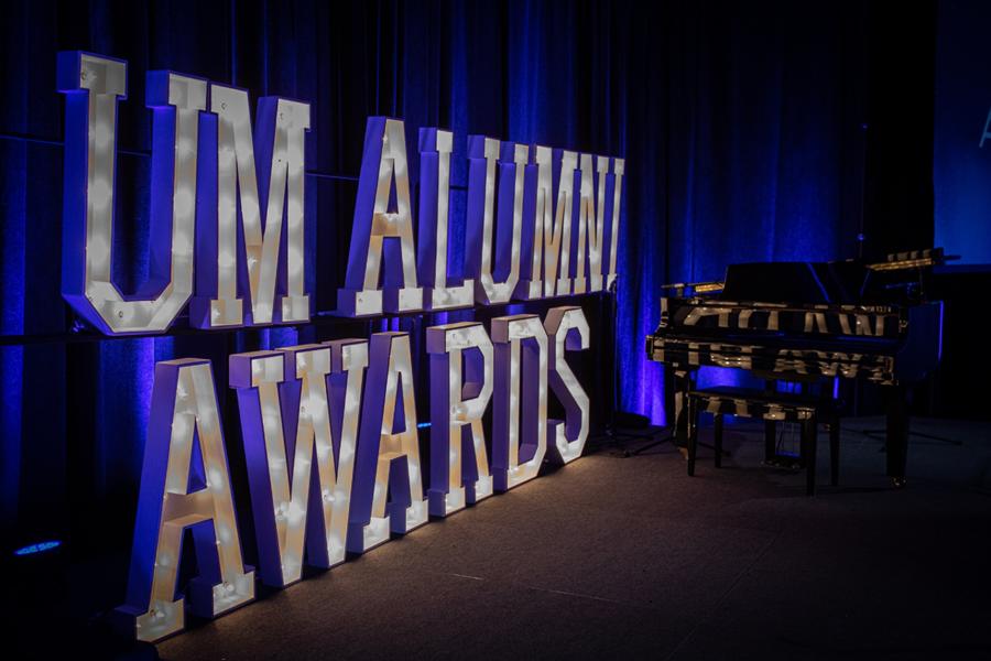 Coloured lights that say 'UM Alumni Awards'.