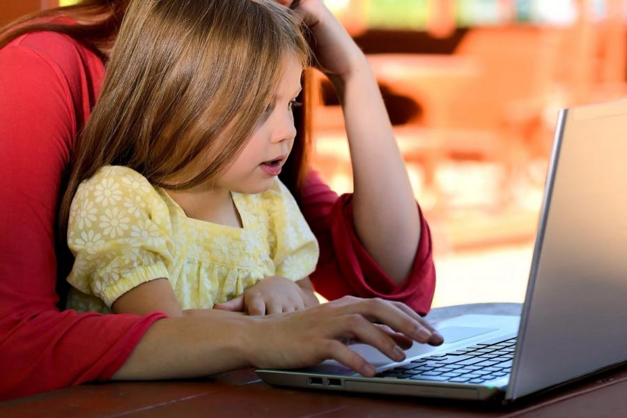 Parent student with child looking at a laptop