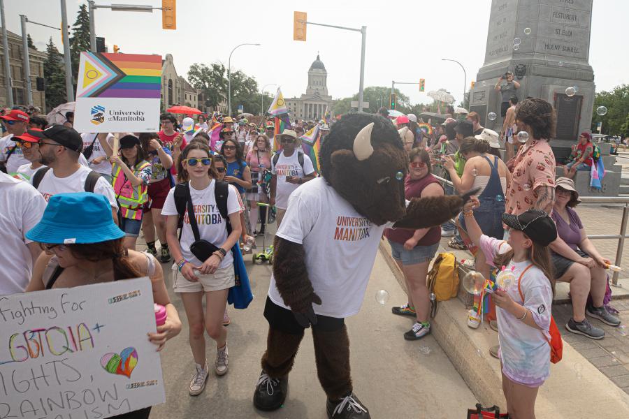 billy the bison mascot highfiving onlookers of the pararde