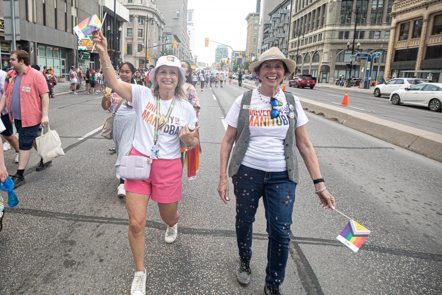 chancellor anne mahon and laurie schnarr walk together at winnipeg pride parade