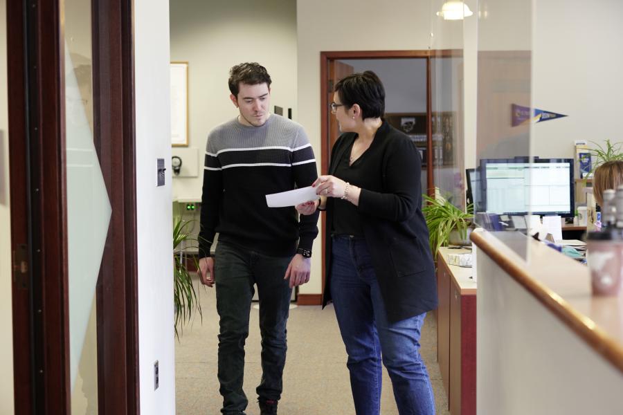 Advisor guiding a student in an office