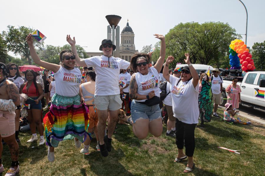 four people jumping in air at pride parade