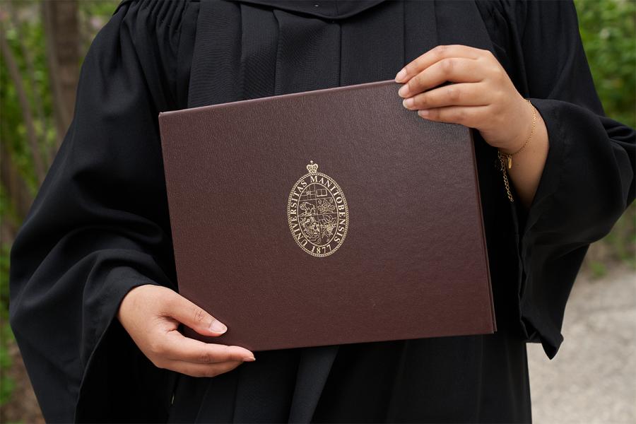 Close up of a student holding their degree.