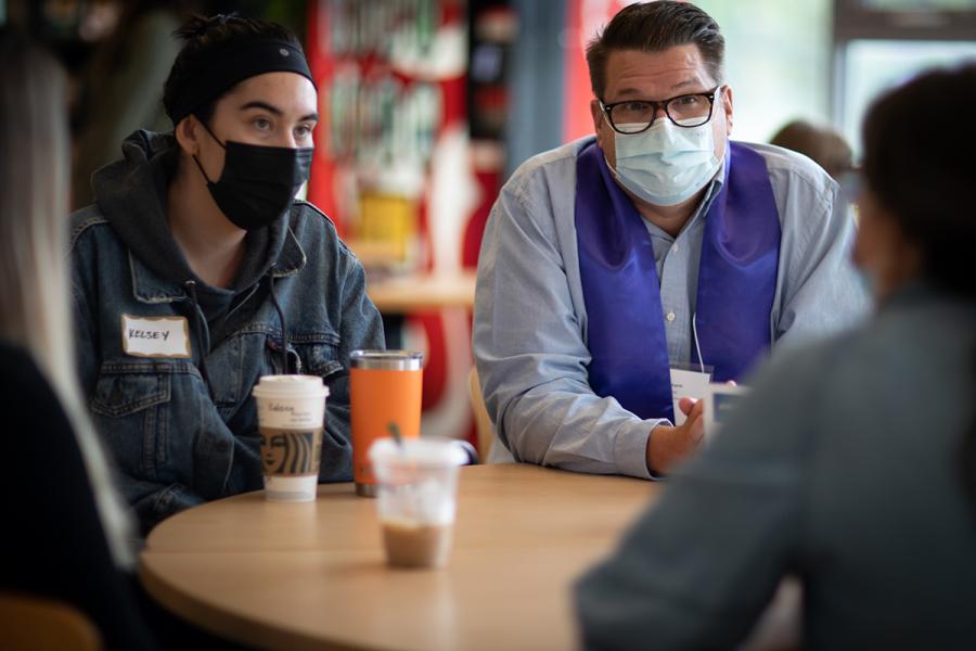 Two people chatting to another person across the table.