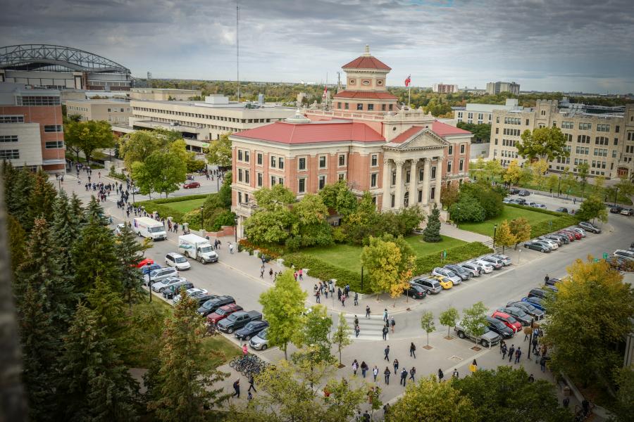 Aerial view of summer at Fort Garry campus with Administration building and students.