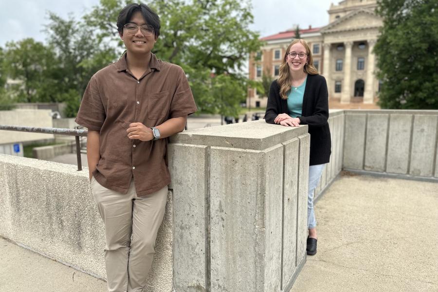 Students standing on the patio in front of trees and the Admin building