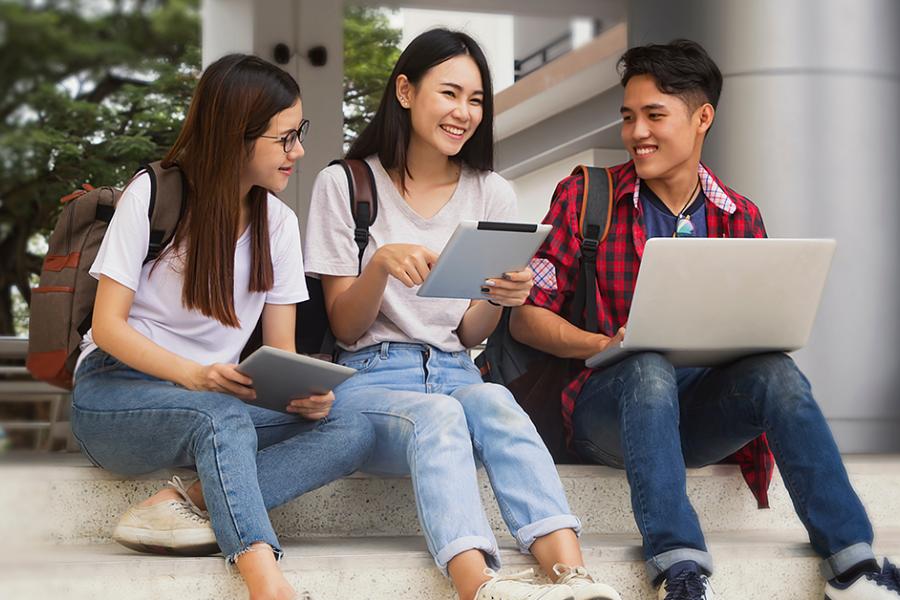 Students sitting together and looking at a laptop