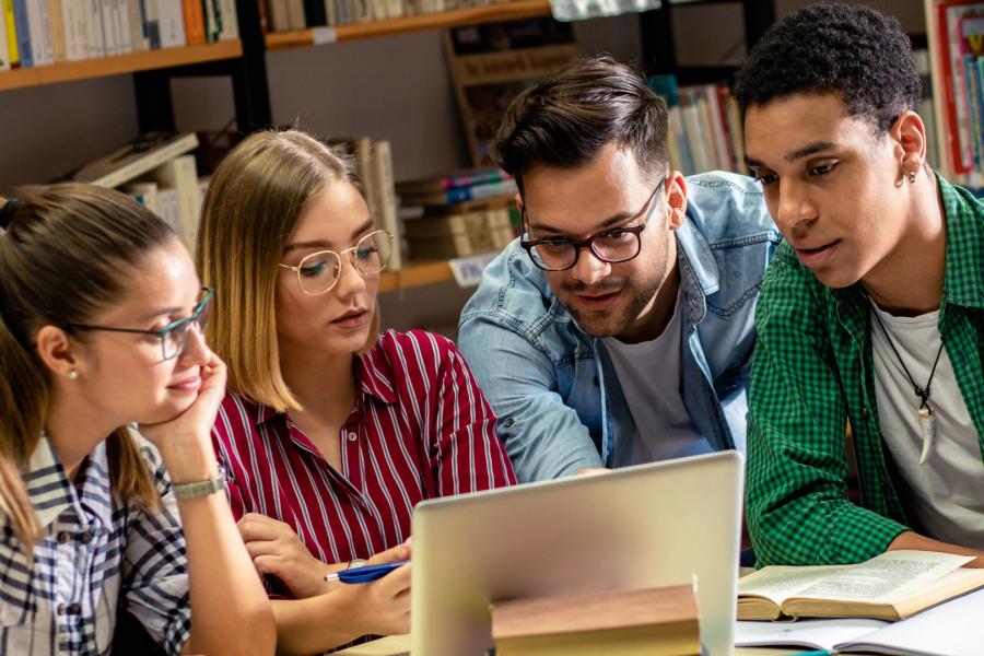 Group of students looking at a laptop.