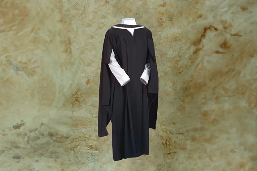 A mannequin wearing a black master's graduation gown, the sleeves have T shaped openings and the gown is long and flowy.